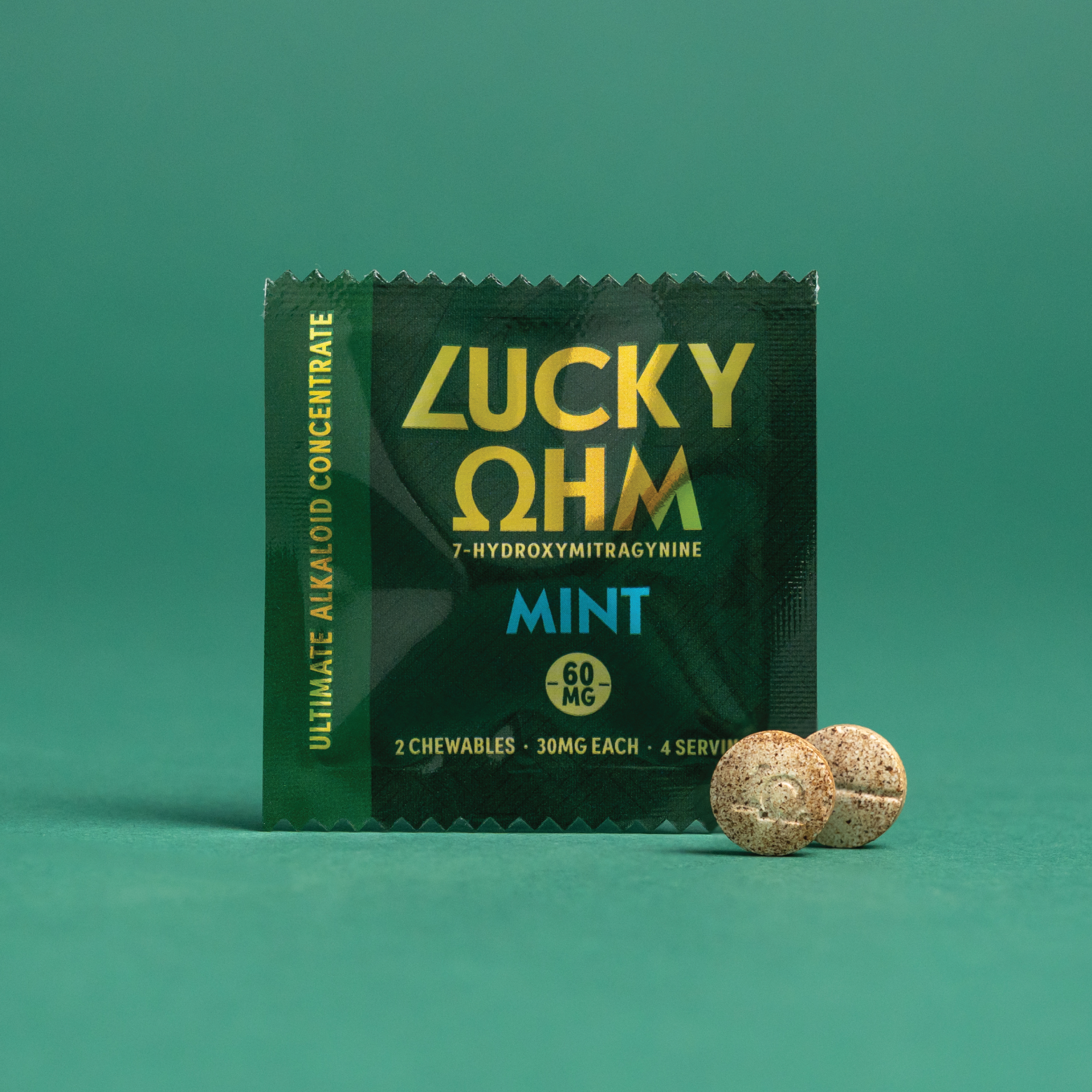 Green packaging of Lucky OHM with two mint chewables on a green background
